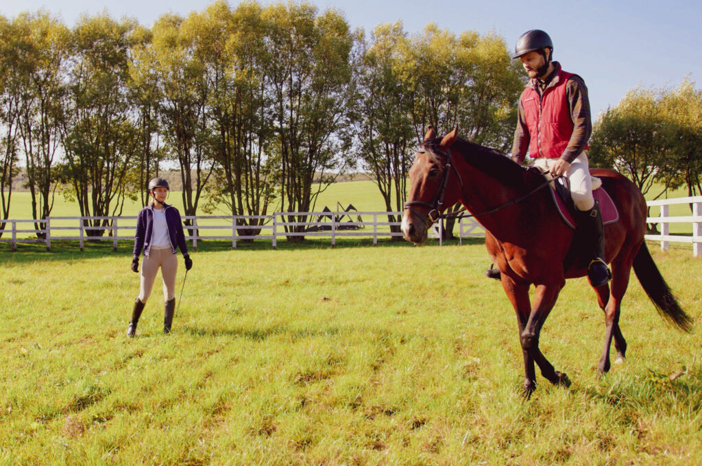 Riding Instructor Teaching Equestrian Student on horse